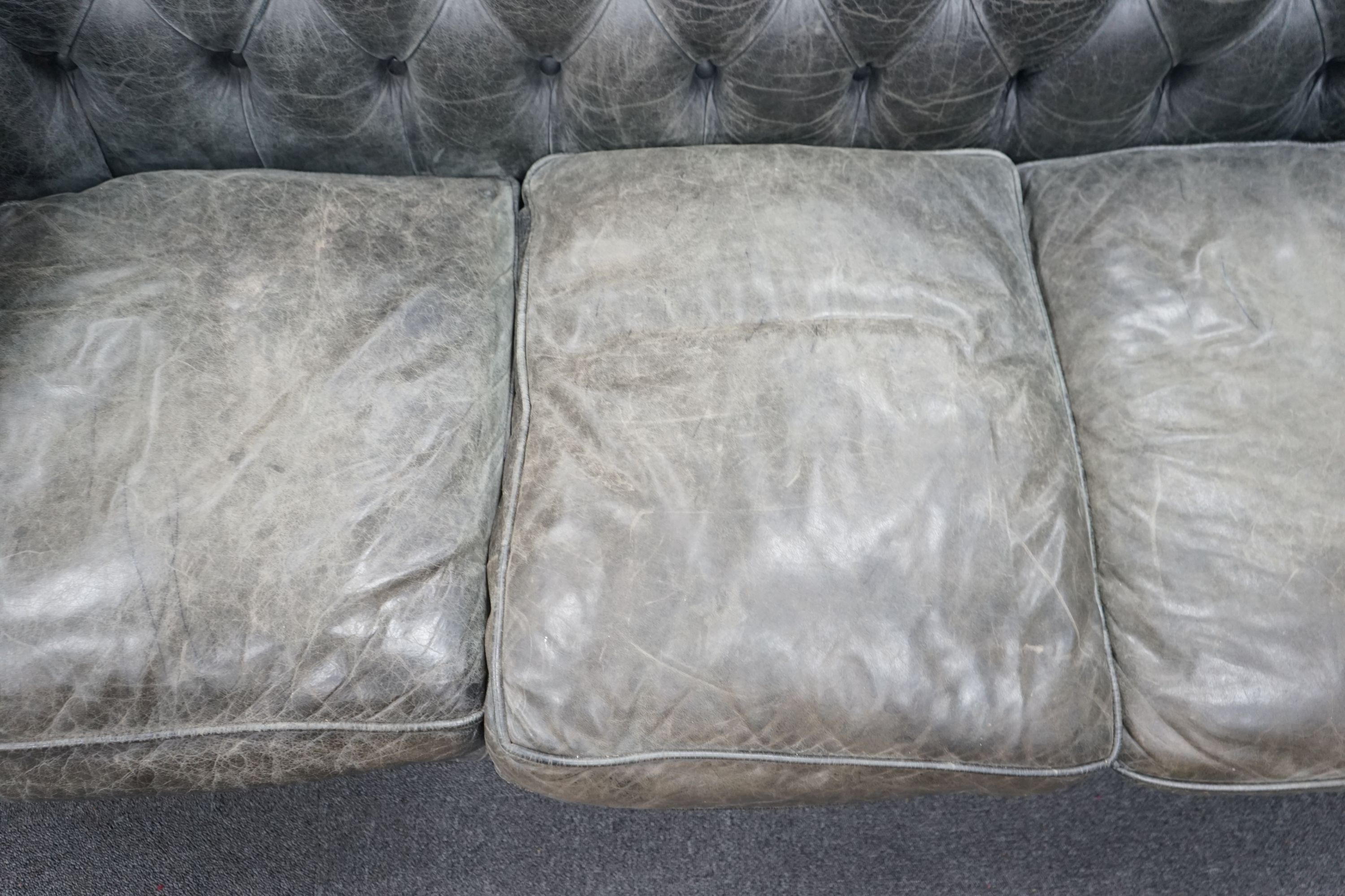 A deep buttoned faded black leather Chesterfield three seater settee, length 210cm, depth 90cm, height 78cm